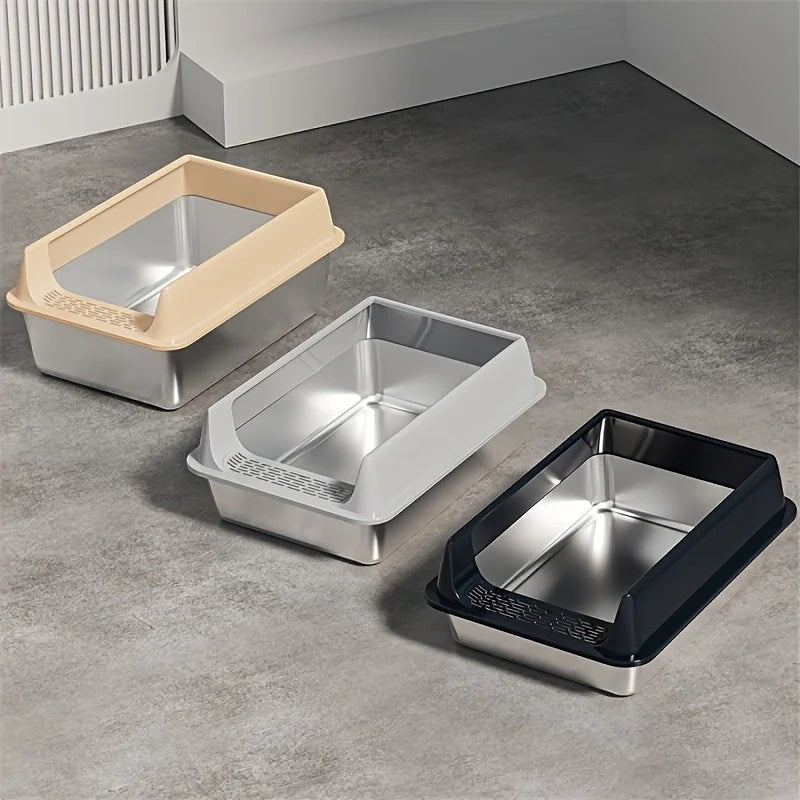 Trois bacs à litière Esprit Chat en acier inoxydable avec rebords colorés beige, gris et noir sur sol gris.