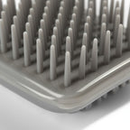 Gros plan sur les picots en plastique gris de la brosse Esprit Chat pour le toilettage et le massage des chats