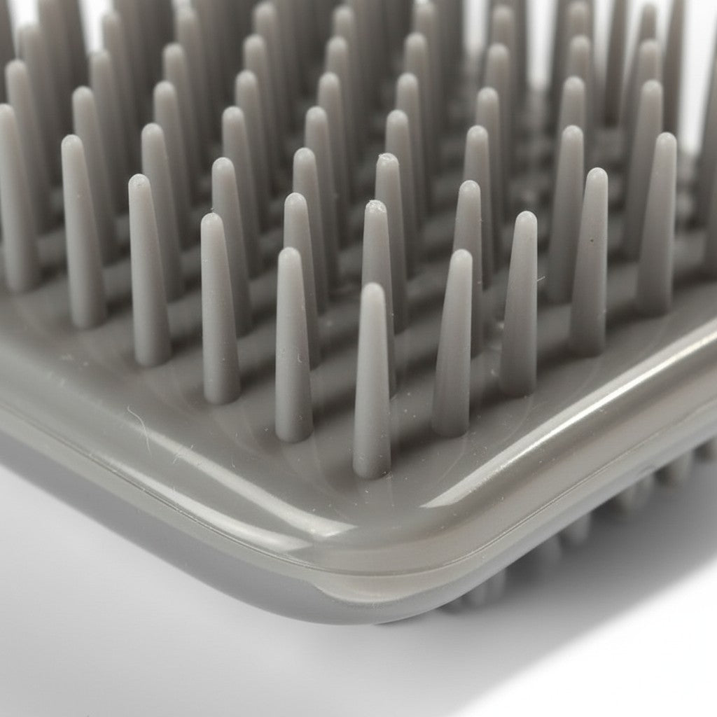 Gros plan sur les picots en plastique gris de la brosse Esprit Chat pour le toilettage et le massage des chats