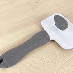 Brosse de toilettage Esprit Chat en plastique blanc et gris pour chat avec bouton poussoir