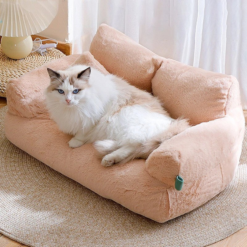 Canapé Esprit Chat en peluche rose pour chat avec dossier confortable et coussin, posé sur un tapis rond.