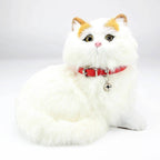 Collier pour chat Esprit Chat en cuir PU rouge avec clochette porté par une figurine de chat blanc en peluche