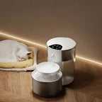 Fontaine à eau automatique Esprit Chat en plastique blanc avec un chat blanc dormant à côté.