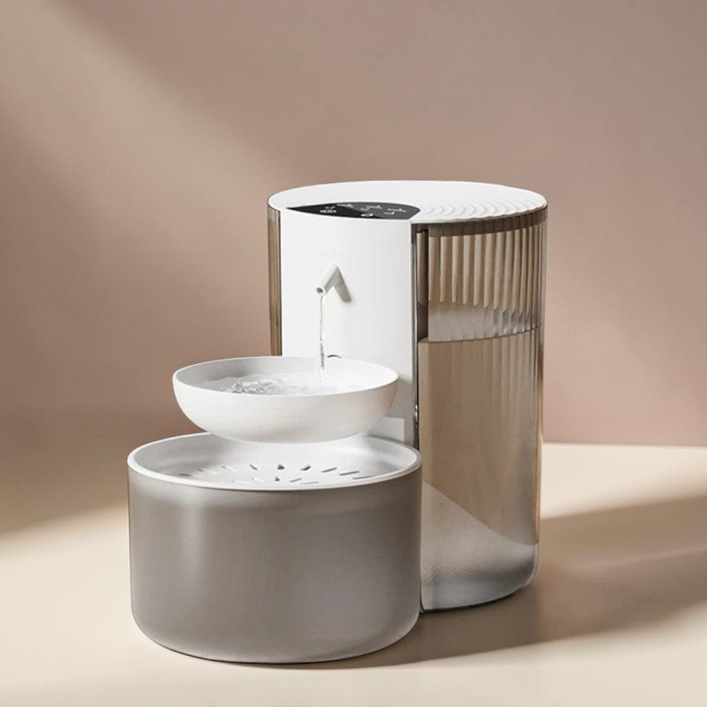 Fontaine à eau automatique en plastique blanc et gris pour chats, avec deux bols et bec verseur.