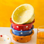 Gamelle Esprit Chat ronde en céramique colorée à pois pour chat empilée sur une table