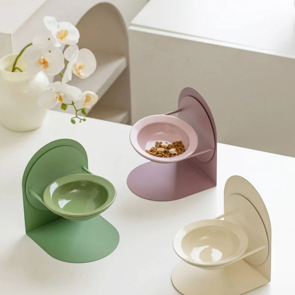Gamelles Esprit Chat en céramique avec support réglable, disponibles en vert, rose et beige sur une table blanche.