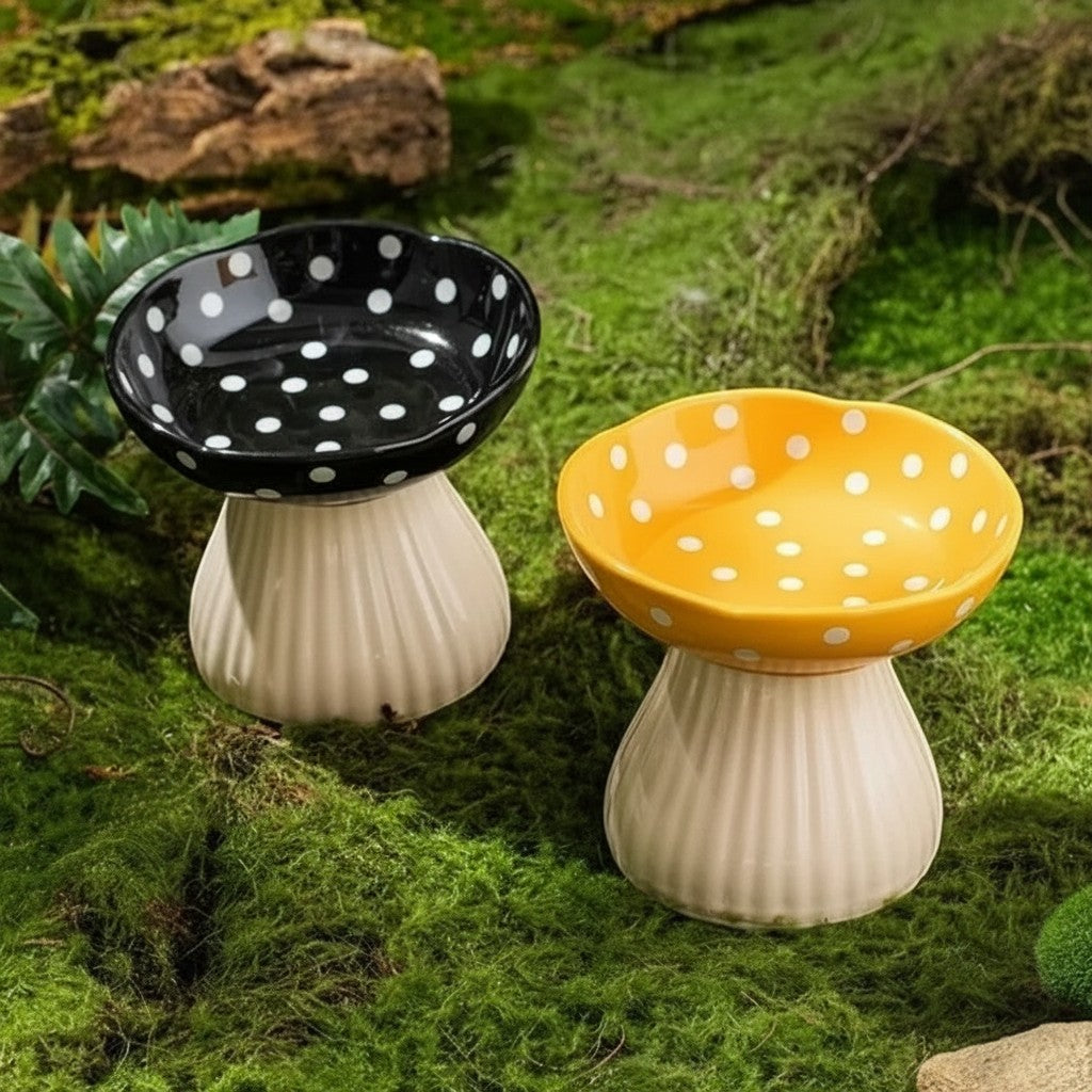 Gamelles pour chat Esprit Chat en forme de champignon, disponibles en noir et jaune, en résine sur un sol moussu.