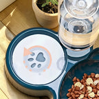 Gamelle ergonomique Esprit Chat en plastique bleu foncé avec distributeur d'eau intégré et motif empreinte de patte.