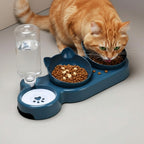 Gamelle ergonomique bleue en plastique pour chat, avec distributeur d'eau intégré et deux bols en forme de tête de chat. Esprit Chat.