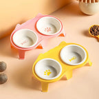 Gamelle double Esprit Chat en céramique avec supports rose et jaune, motifs patte et arête de poisson pour chat