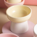 Gamelle surélevée pour chat Esprit Chat en céramique jaune et blanche au design arrondi et ergonomique