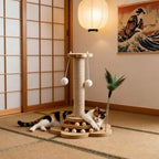 Griffoir chat vertical Esprit Chat en bois naturel avec poteau en sisal et jouets suspendus, un chat tricolore joue avec.