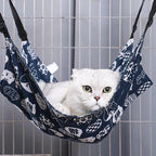 Chat blanc reposant dans un hamac Esprit Chat en tissu bleu respirant avec motifs de chats pour cage