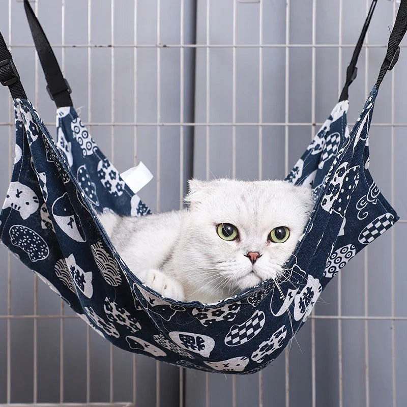 Chat blanc reposant dans un hamac Esprit Chat en tissu bleu respirant avec motifs de chats pour cage