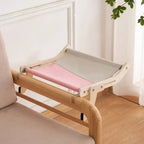 Hamac pour chat Esprit Chat en bois avec toile bicolore rose et grise, suspendu sur un dossier de chaise