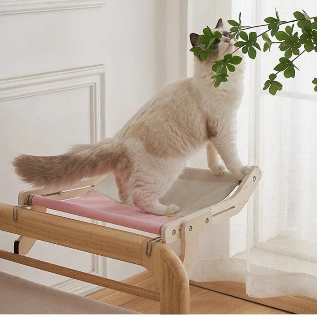 Hamac pour chat Esprit Chat en bois avec toile rose, installé sur un rebord de fenêtre pour le repos de l'animal