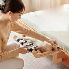 Hamac pour chat Esprit Chat en bois avec tissu à carreaux noir et blanc fixé au bord d'un lit
