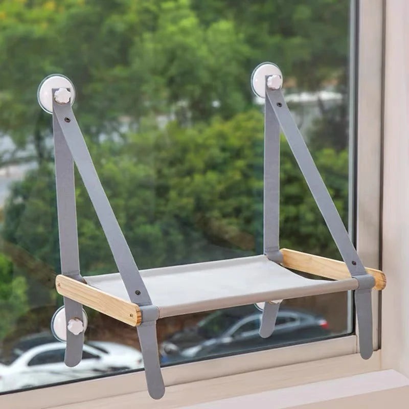 Hamac pour chat Esprit Chat pliable en bois et tissu gris, fixé à une fenêtre par des ventouses robustes.