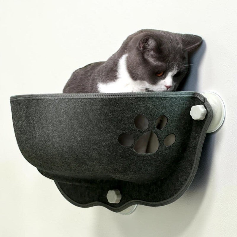 Hamac de fenêtre Esprit Chat en feutre gris foncé avec motif patte pour chat installé sur une vitre