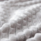 Gros plan sur la texture douce et respirante en velours côtelé blanc du lit pour chat Esprit Chat