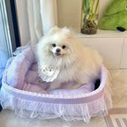 Petit chien blanc assis dans un lit douillet Esprit Chat violet à carreaux avec jupe en tulle et bords surélevés