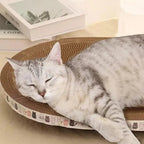 Chat gris dormant sur un lit griffoir en carton ondulé Esprit Chat, accessoire confortable pour griffes et sieste.