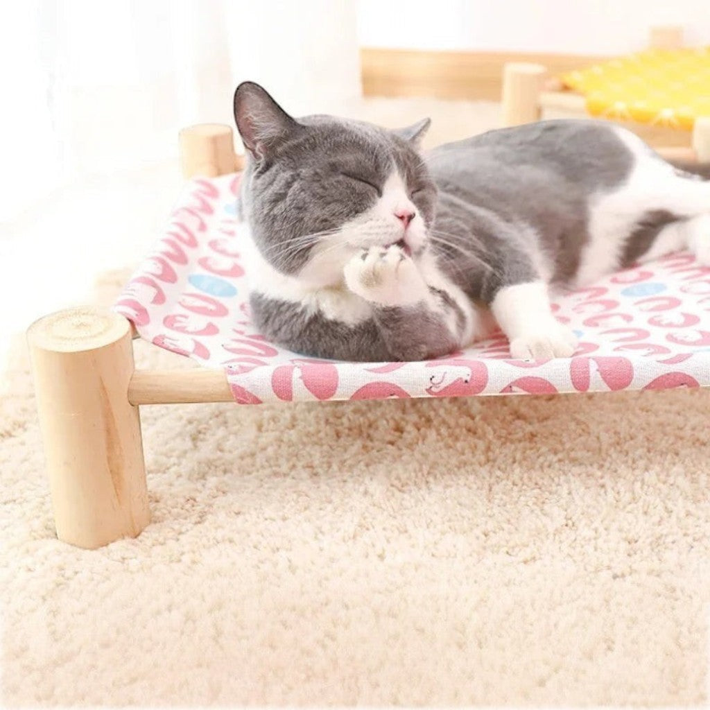 Lit hamac surélevé Esprit Chat en bois avec toile rose à motifs pour le confort et la ventilation de votre chat