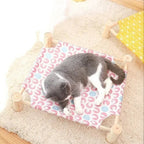 Lit hamac surélevé Esprit Chat en bois avec toile à motifs colorés pour le repos confortable d'un chat gris et blanc