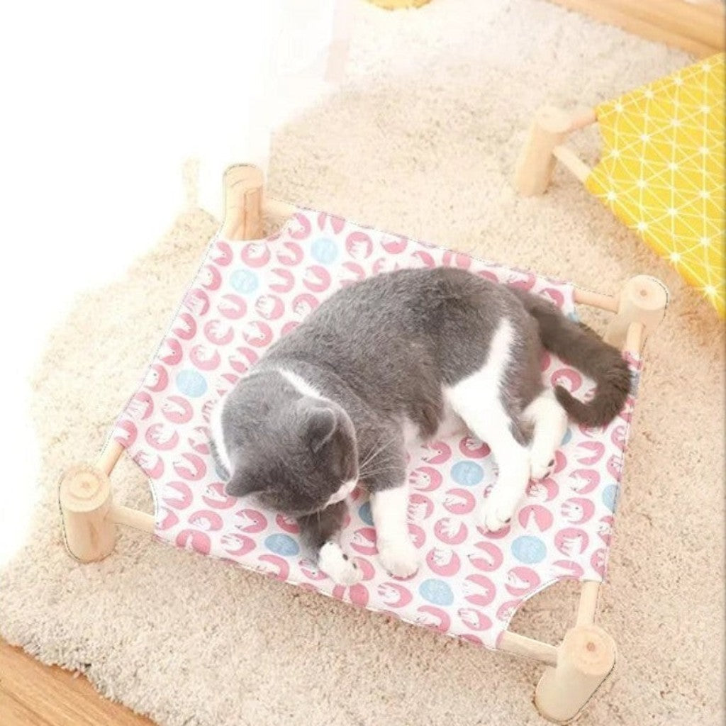 Lit hamac surélevé Esprit Chat en bois avec toile à motifs colorés pour le repos confortable d'un chat gris et blanc