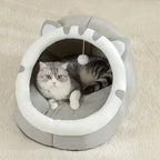 Maison pour chat Esprit Chat en coton gris en forme de tête de chat avec un jouet suspendu et un chat à l'intérieur