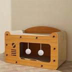 Maison griffoir en bois Esprit Chat avec zones à griffer, plateforme supérieure et deux jouets pompons suspendus.