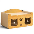 Maison griffoir en bois Esprit Chat avec ouvertures en forme de tête de chat et balles suspendues pour le jeu.