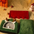 Maison de Noël pour chat Esprit Chat en peluche verte avec bois de renne, incluant un coussin rouge et un tapis vert.