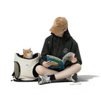Sac de transport pliable Esprit Chat en nylon beige et noir pour chien ou chat, porté en bandoulière par une femme.