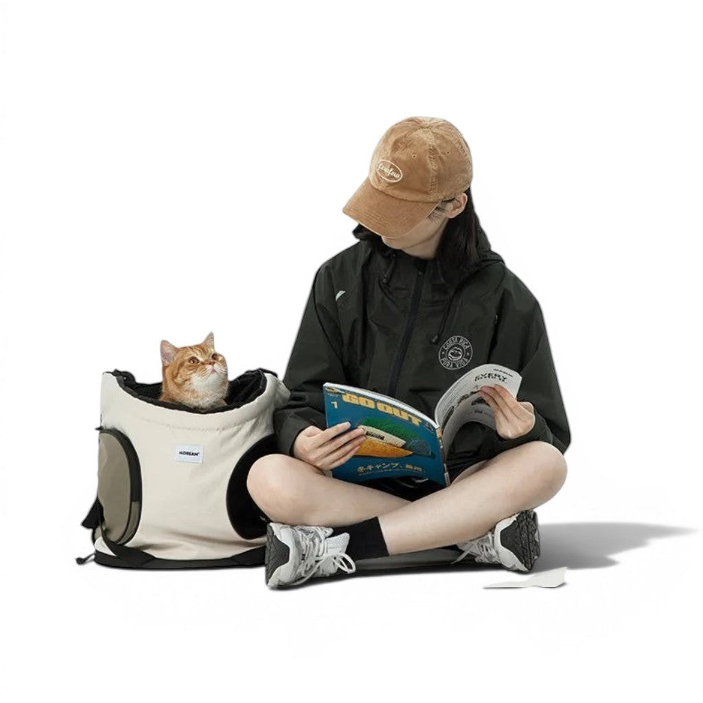 Sac de transport pliable Esprit Chat en nylon beige et noir pour chien ou chat, porté en bandoulière par une femme.