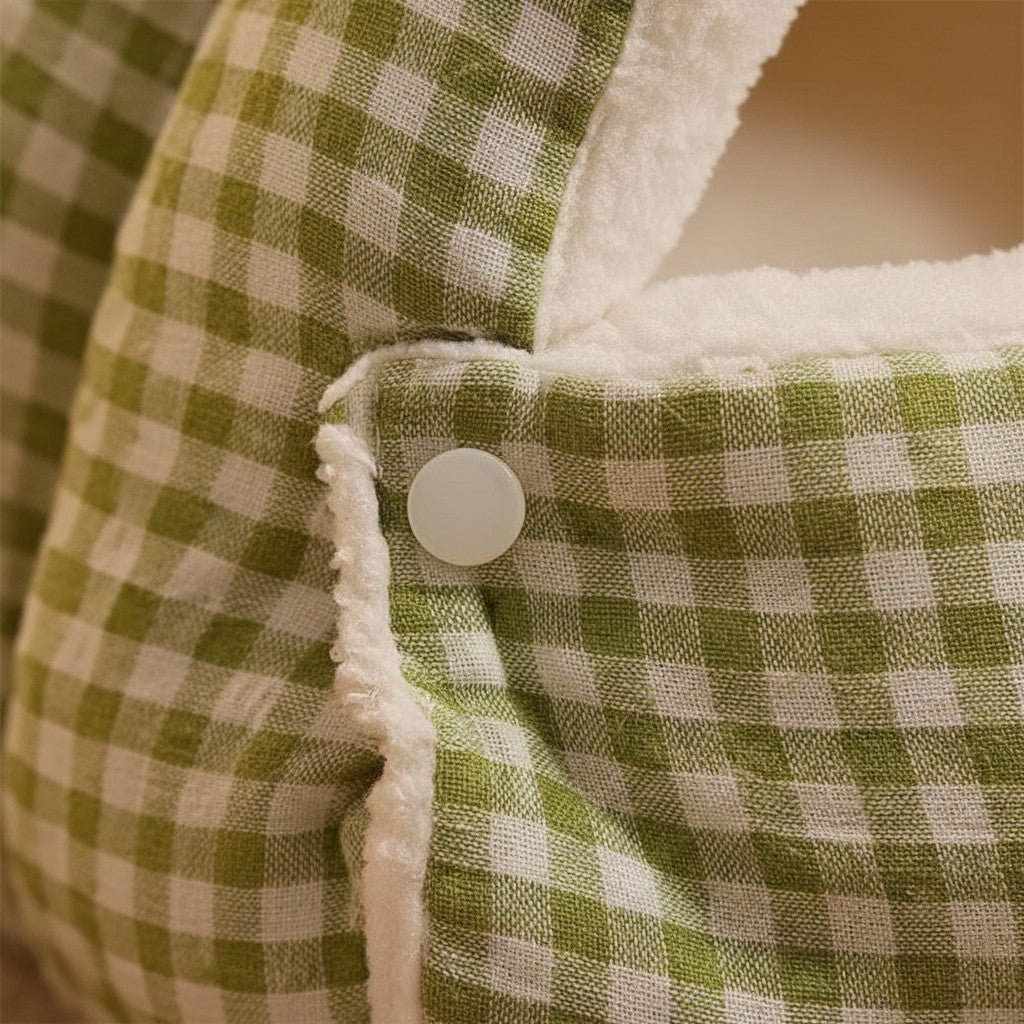 Détail du bouton pression sur un tapis lit pour chat Esprit Chat en tissu à carreaux verts et blancs avec doublure