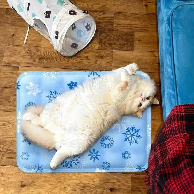 Chat blanc allongé sur un tapis rafraîchissant bleu Esprit Chat avec des motifs de flocons de neige