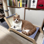 Chat roux et blanc allongé sur un transat Esprit Chat en bois avec un tissu rayé bleu et blanc