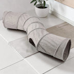 Tunnel pour chat Esprit Chat pliable en suédine grise, forme en S avec ouverture latérale pour le jeu et l'exercice.